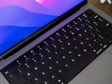 A close-up of hands typing on a sleek laptop keyboard.