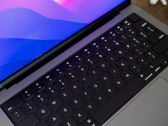 A sleek laptop screen displaying a colorful typing test interface with real-time feedback.