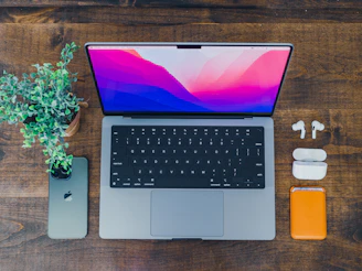 A vibrant workspace featuring a laptop, smartphone, and various tech accessories neatly arranged on a wooden desk.