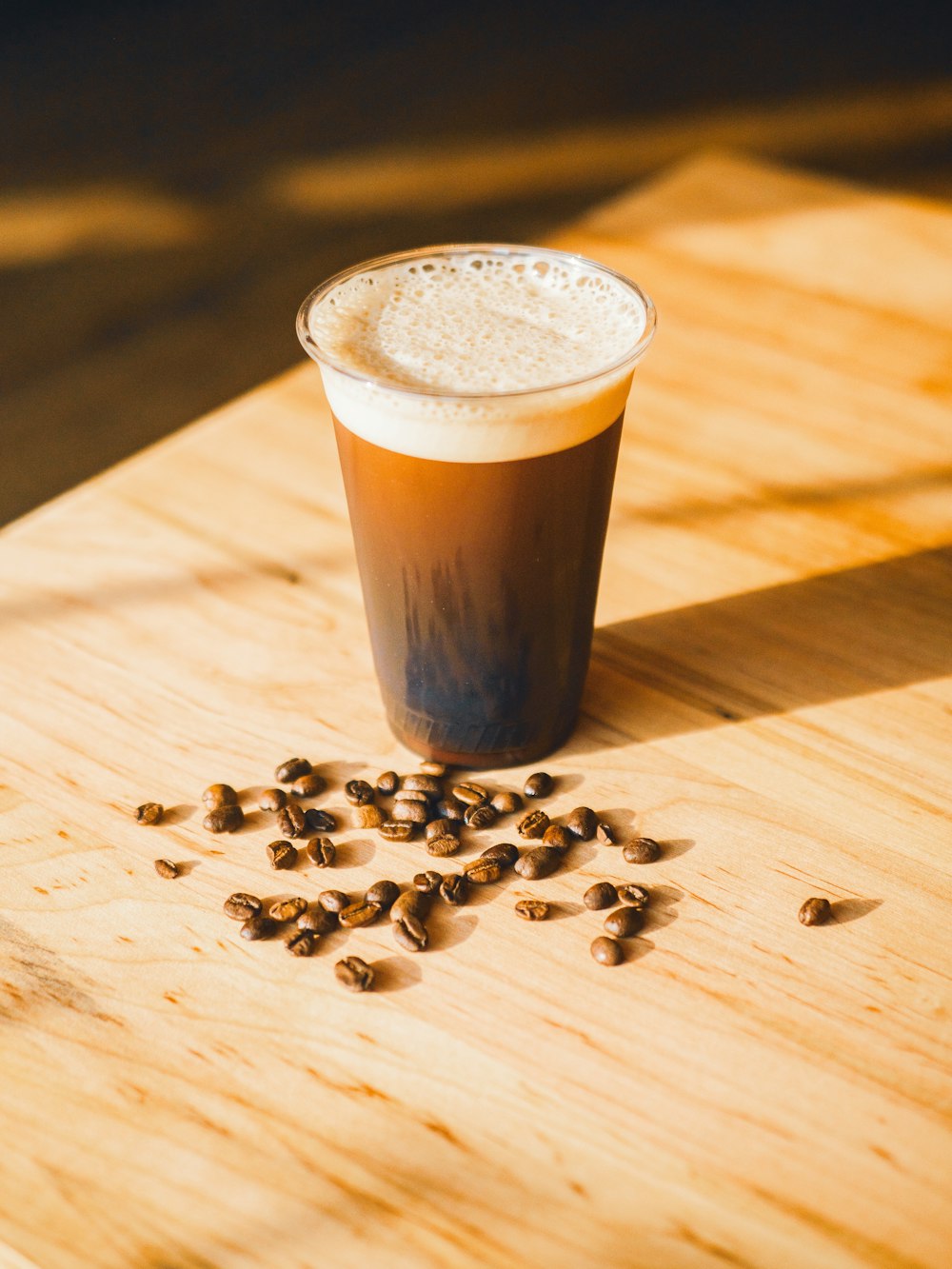 a glass of coffee with coffee beans