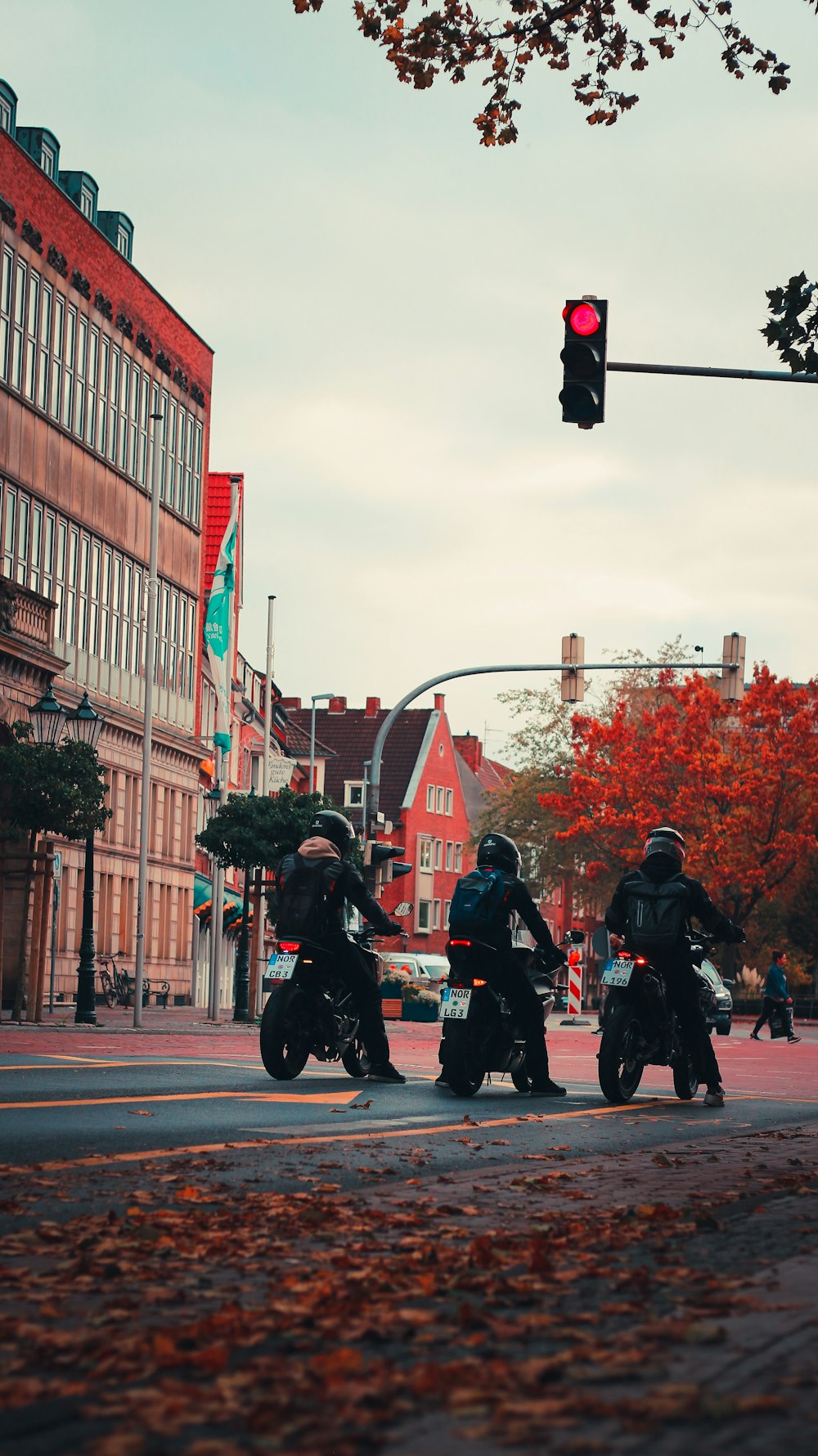 a group of people ride motorcycles down a street