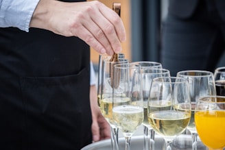 a person pouring a glass of wine