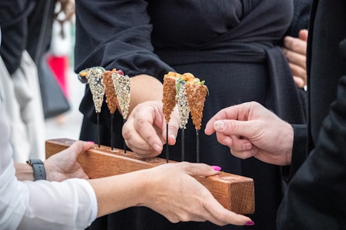 a group of hands holding a piece of wood