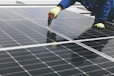 Technicians performing maintenance on solar panels at sunrise