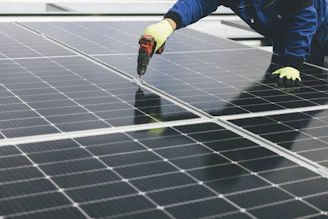 Technician inspecting and maintaining a solar panel array at a modern industrial park