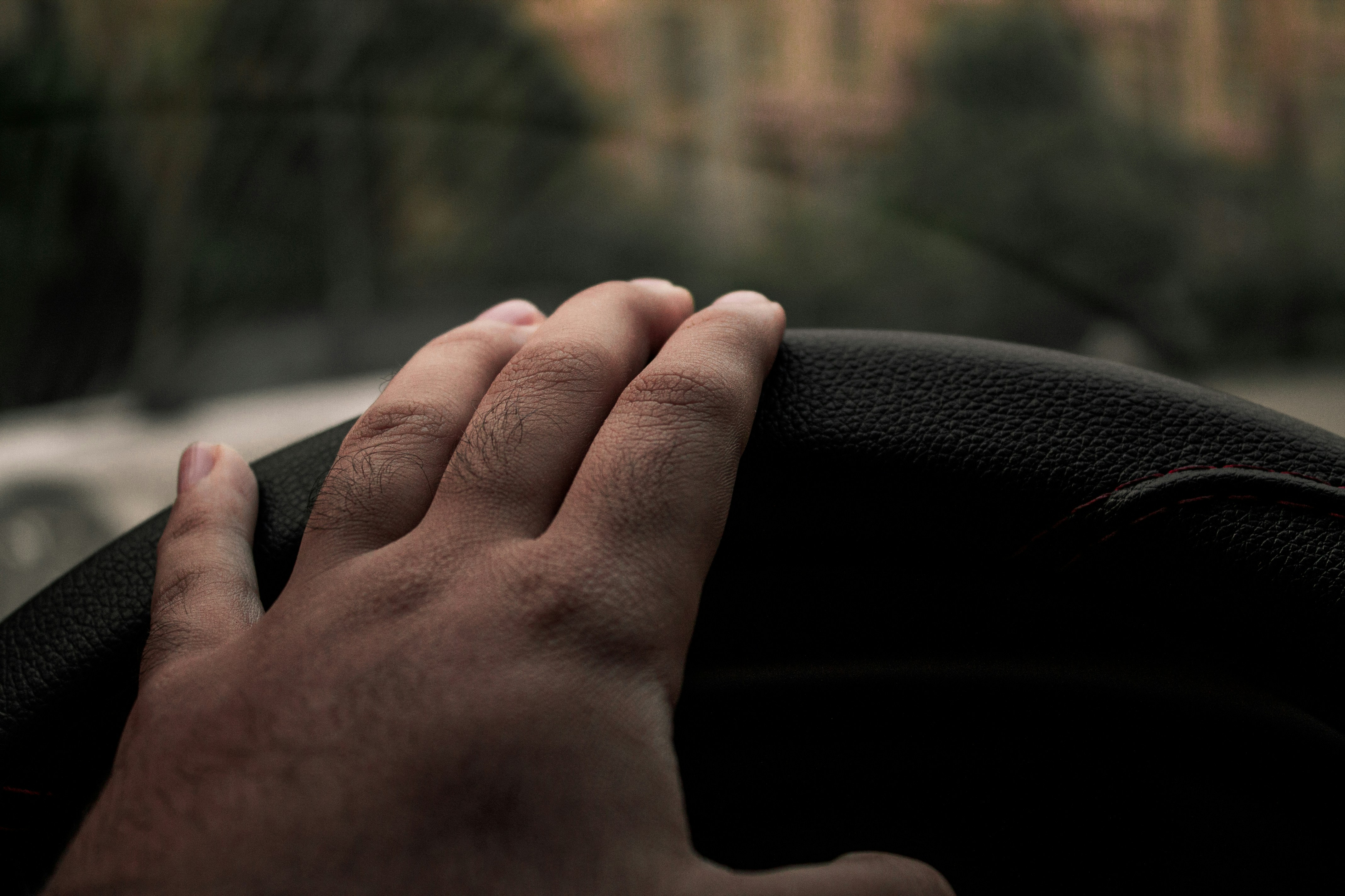 a person's hand on a leather chair