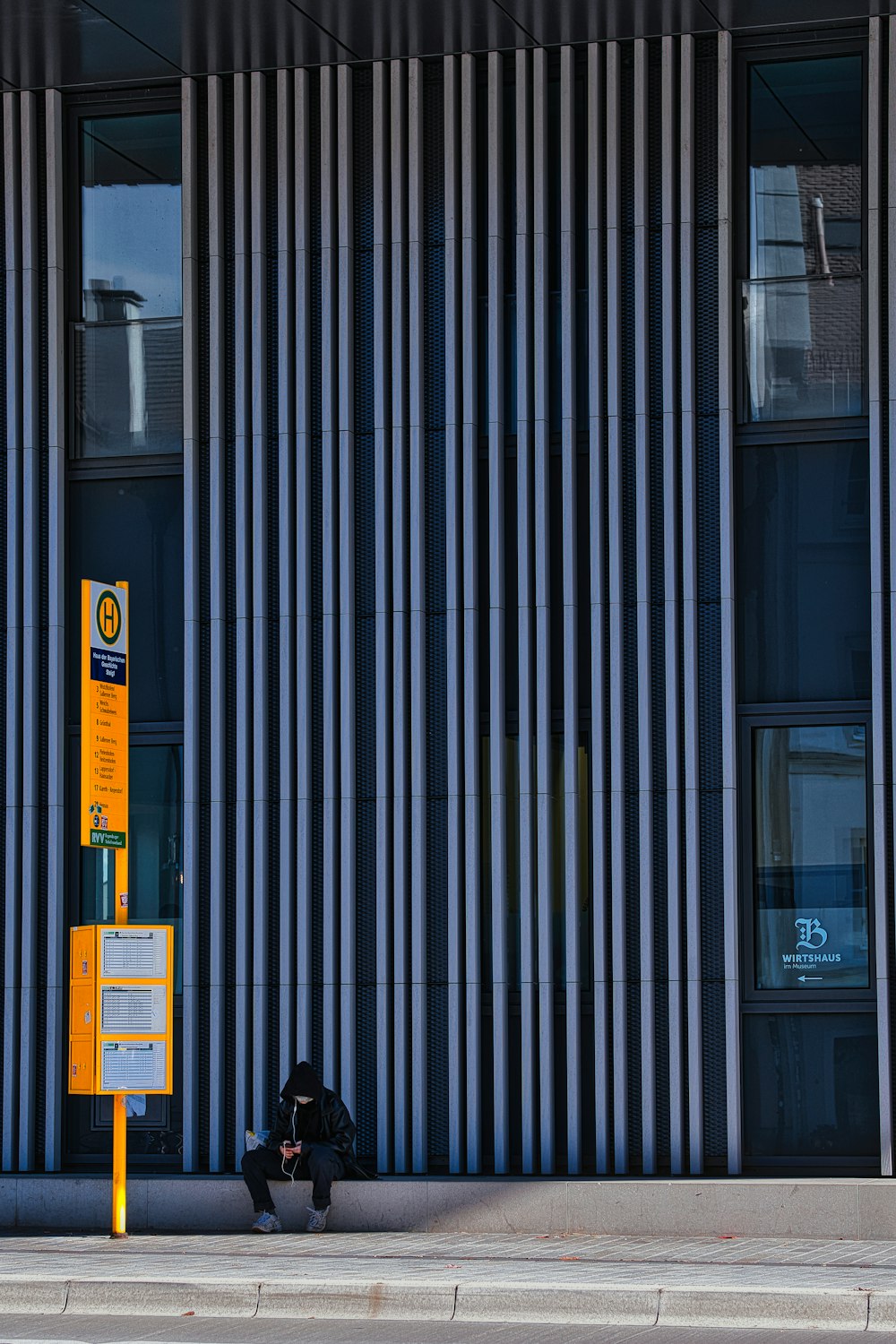 a person sitting on a sidewalk