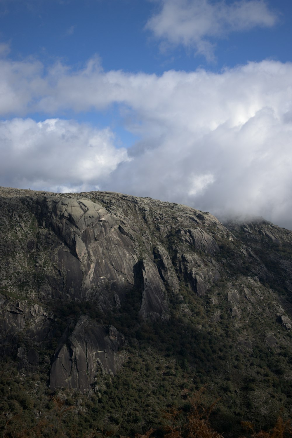 Une montagne avec des arbres et des nuages