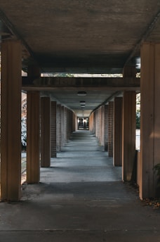 a long hallway with wood pillars