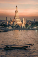 a boat in the water with a large building in the background