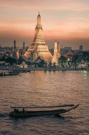 a boat in the water with a large building in the background