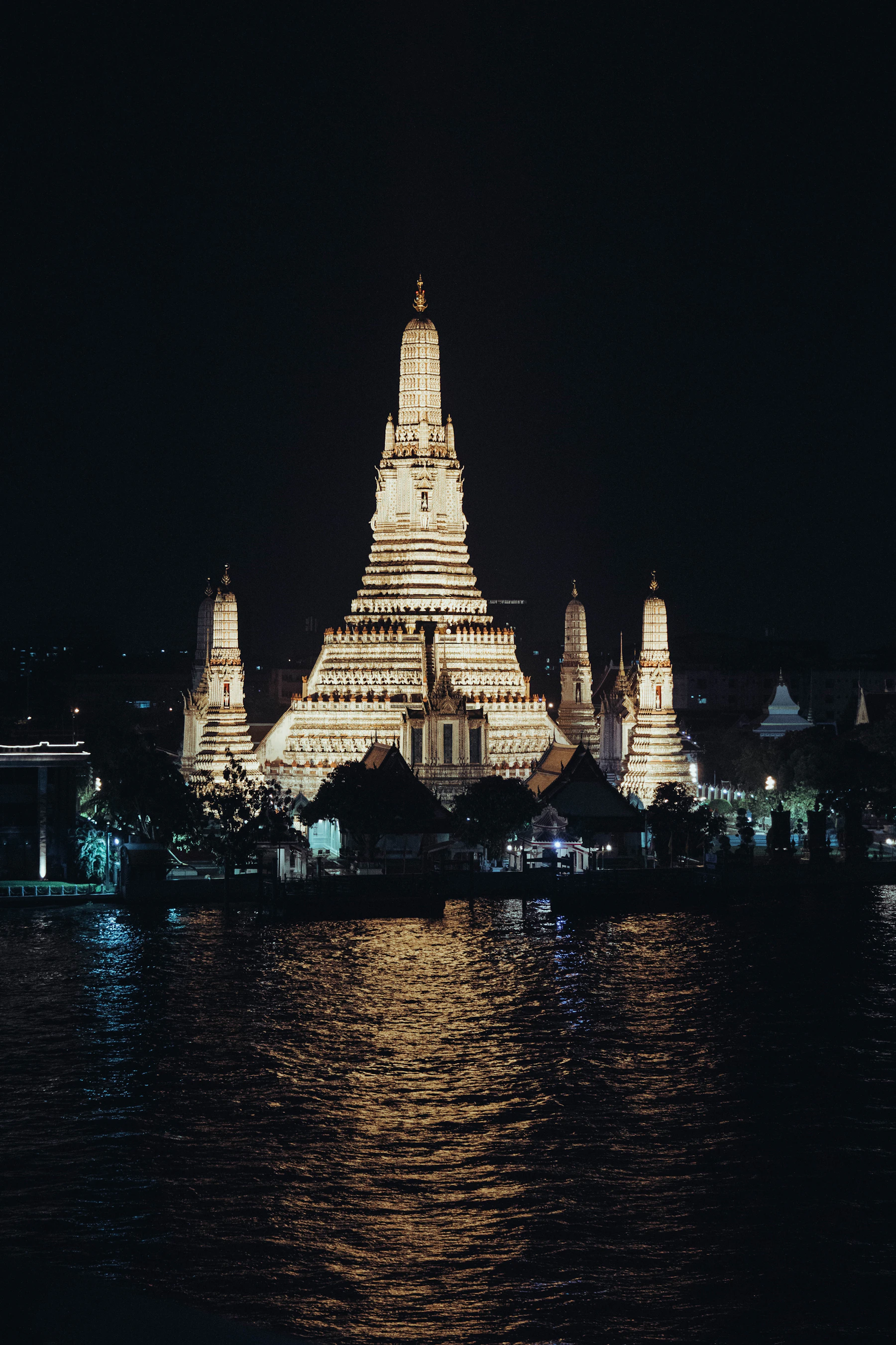 Bangkok's illuminated Wat Arun temple reflected in the Chao Phraya River at night