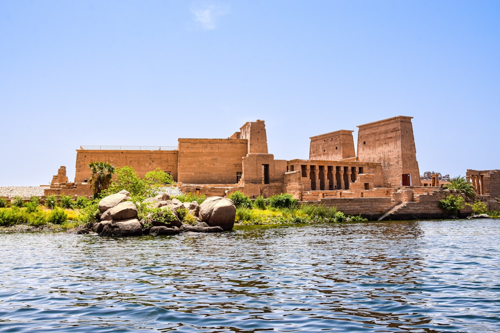 a large building on a hill by the water with Philae in the background
