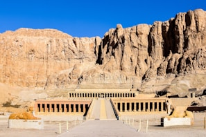 a large building with a mountain in the background