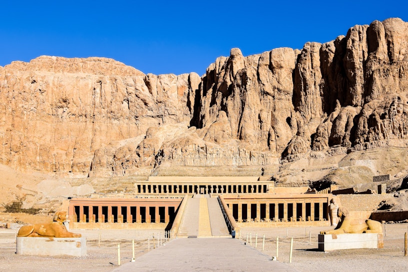a large building with a mountain in the background