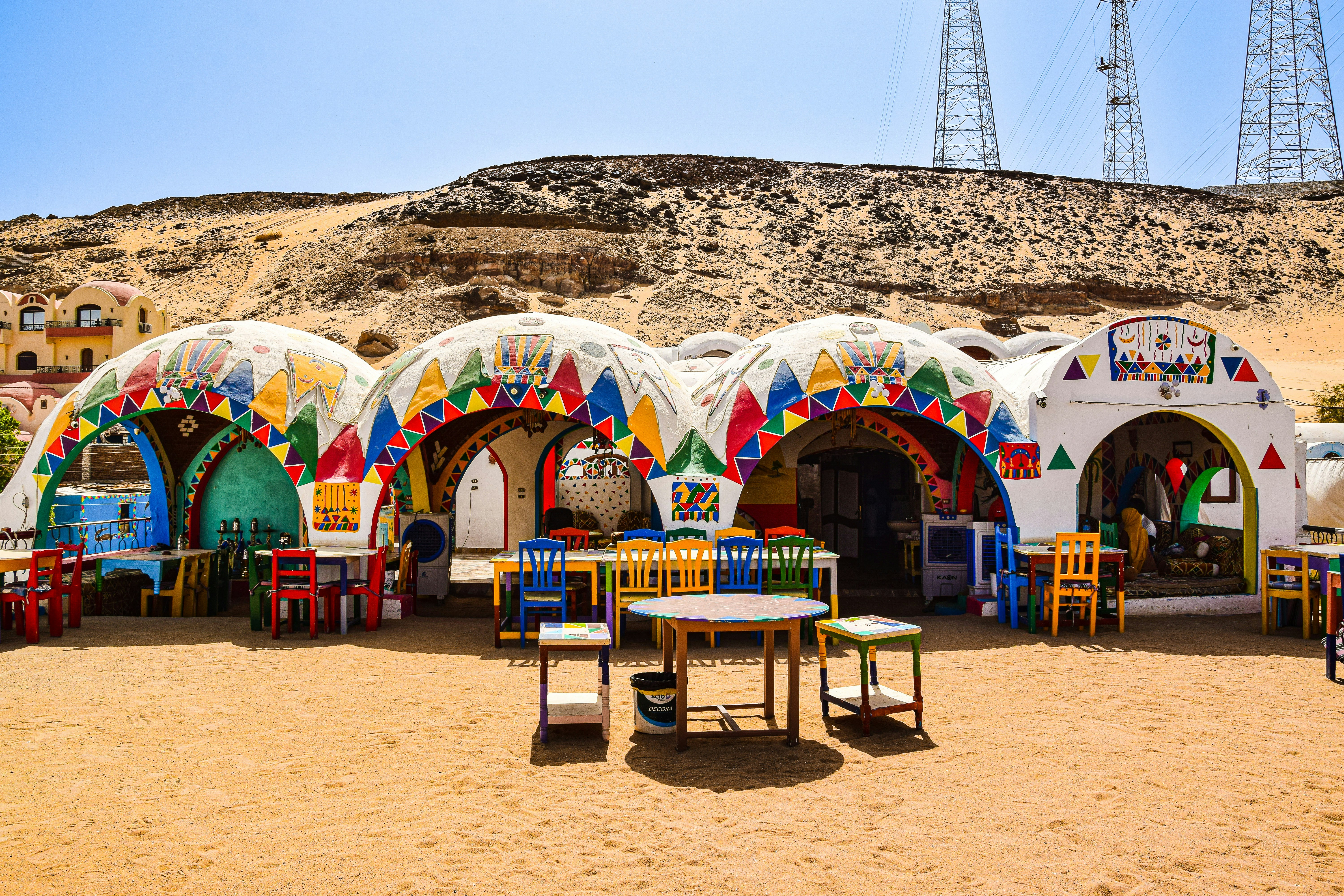 a group of colorful buildings with a hill in the background, Aswan, Egypt.