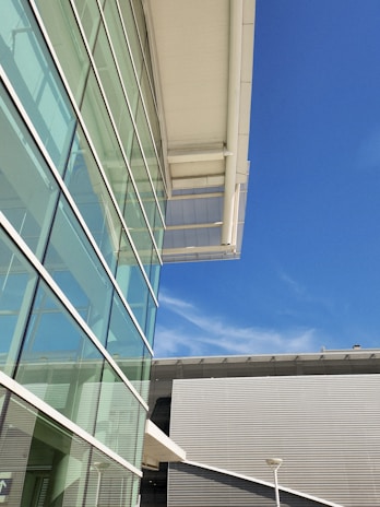 A sleek, modern modular steel home with large windows set against a clear blue sky.