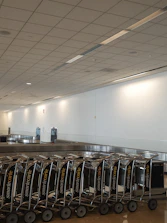 A robust dolly rack neatly organized in a busy airport cargo area.