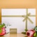 A white gift box tied with an olive green ribbon is centrally displayed against a muted mustard background. The box is accompanied by two pink protea flowers and green foliage at the bottom corners. A small card with the words 'gift&crate' is placed below the box.
