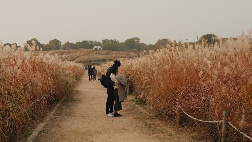 a group of people walking on a dirt road