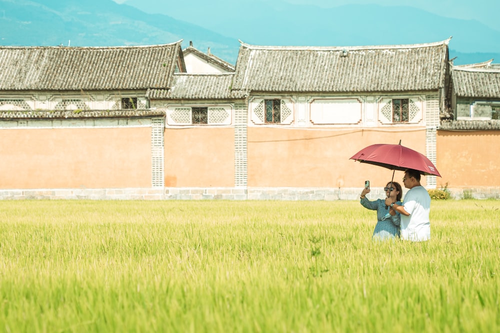 a couple of people stand under an umbrella