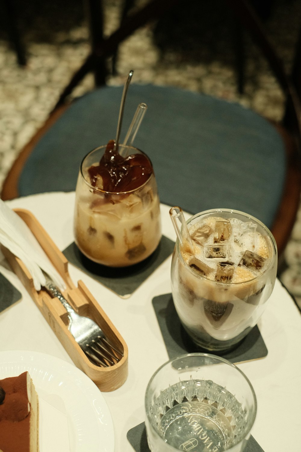 a table with a couple of glasses of ice cream and a spoon