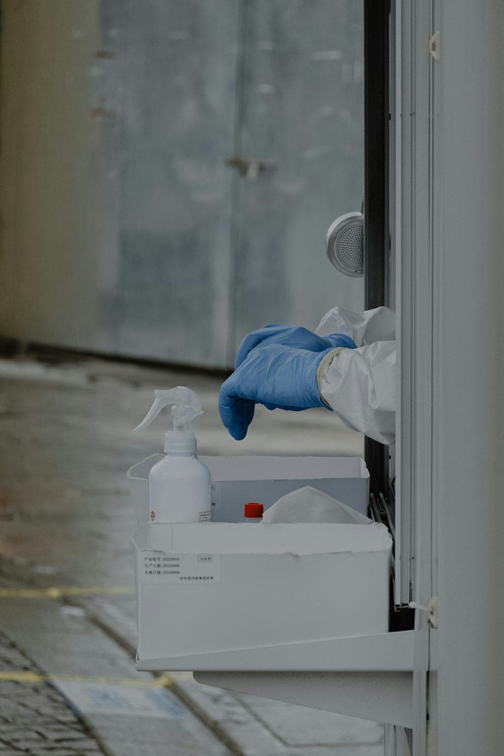 a person wearing gloves and gloves holding a white container with a white substance