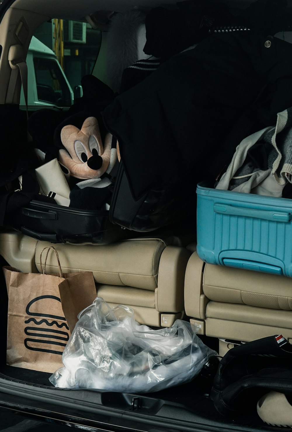 a person in a car with a bag and a bag of trash