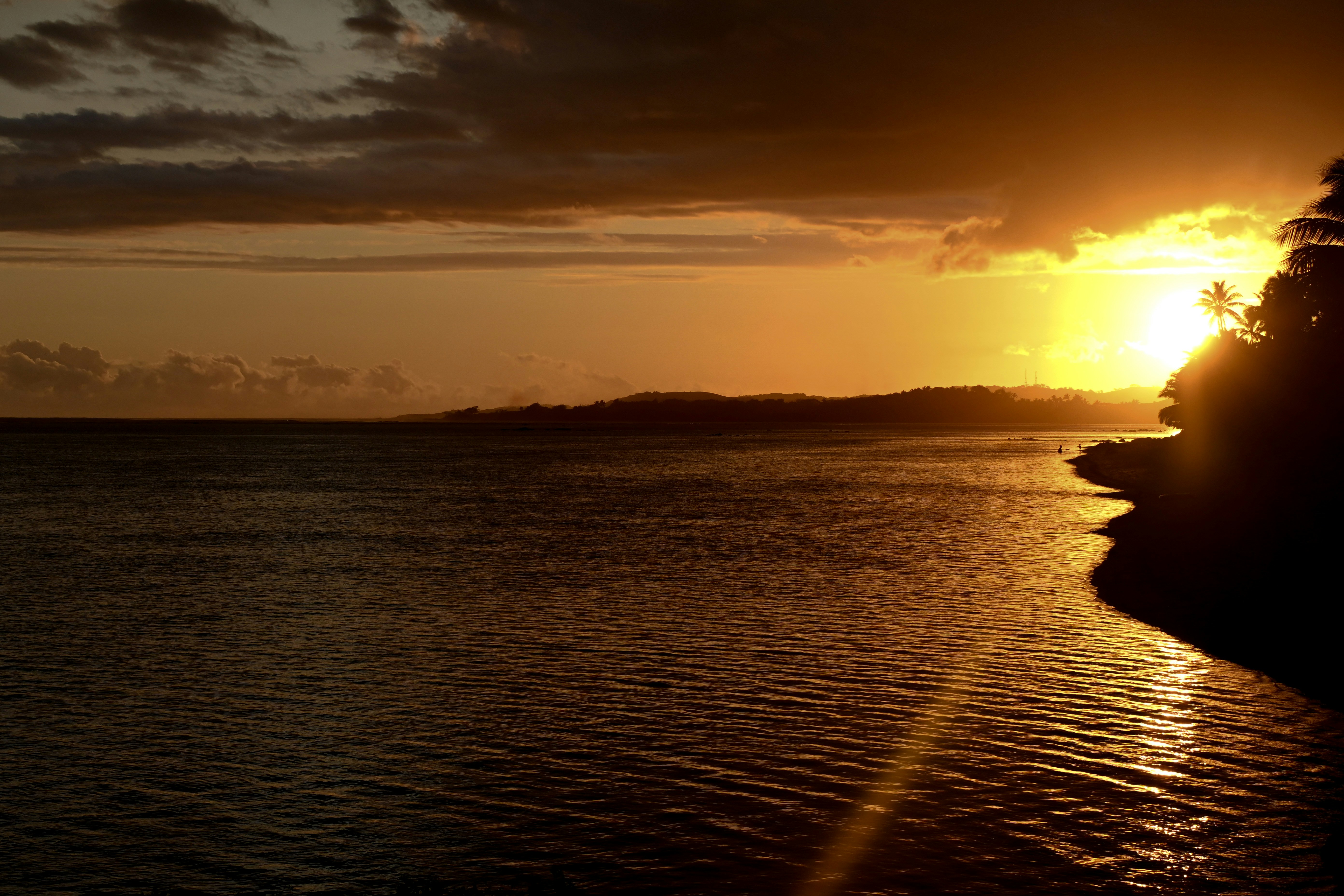 a body of water with a sunset, 