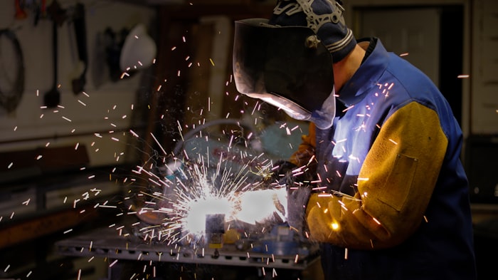 Worker in blue protective gear on machine