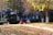 A family of four enjoying a picnic in a colorful autumn park.