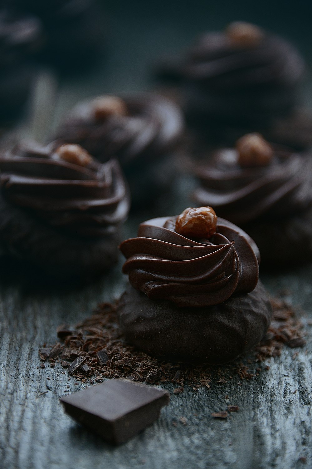 a chocolate cupcake with chocolate frosting and a small chocolate bar