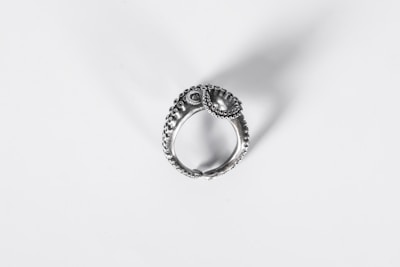 Close-up of a silver 925 ring with intricate modern design on a soft fabric background