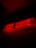 A glowing red exit sign with the words 'EXIT SORTIE' displayed against a dark background, illuminated in a strong red light.