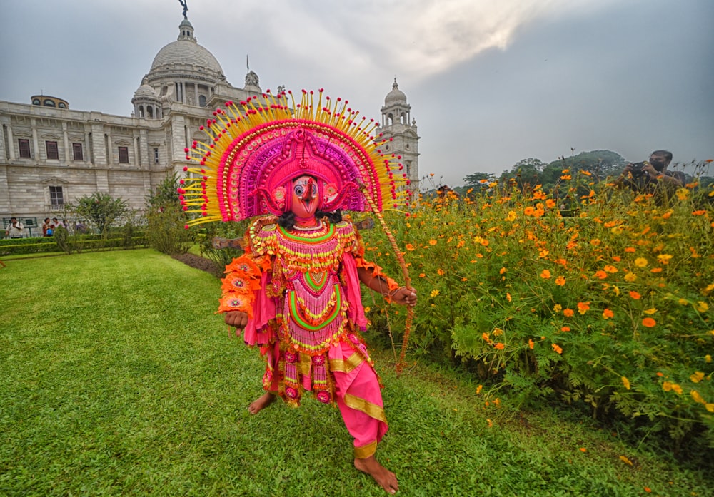 a person in a garment in front of a building with a dome