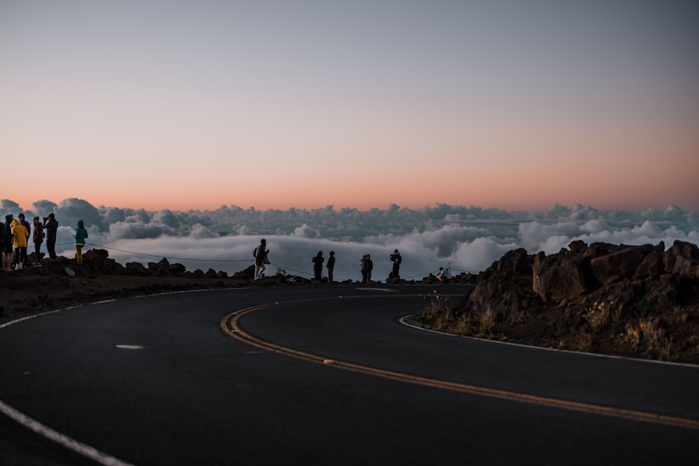 a group of people standing on a road with fog around