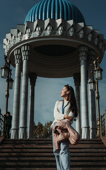 a person standing on stairs in front of a building with columns