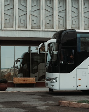 Executive coach bus parked in front of a corporate building.