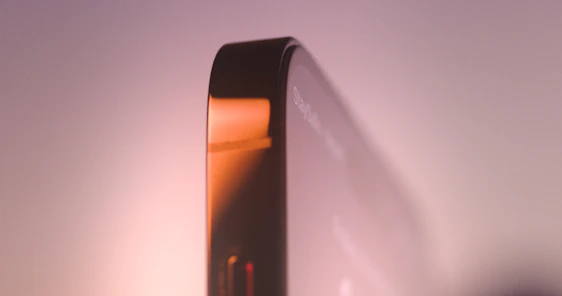 A close-up of a sleek smartphone protected by a Zagg screen protector, with a soft glow highlighting its flawless surface.