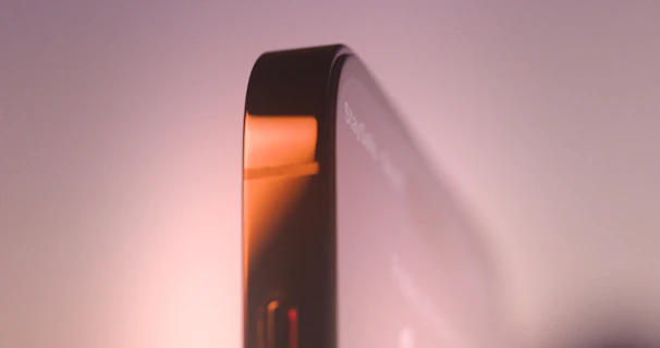 A sleek smartphone with a crystal-clear protective screen shield reflecting ambient light in a modern setting.