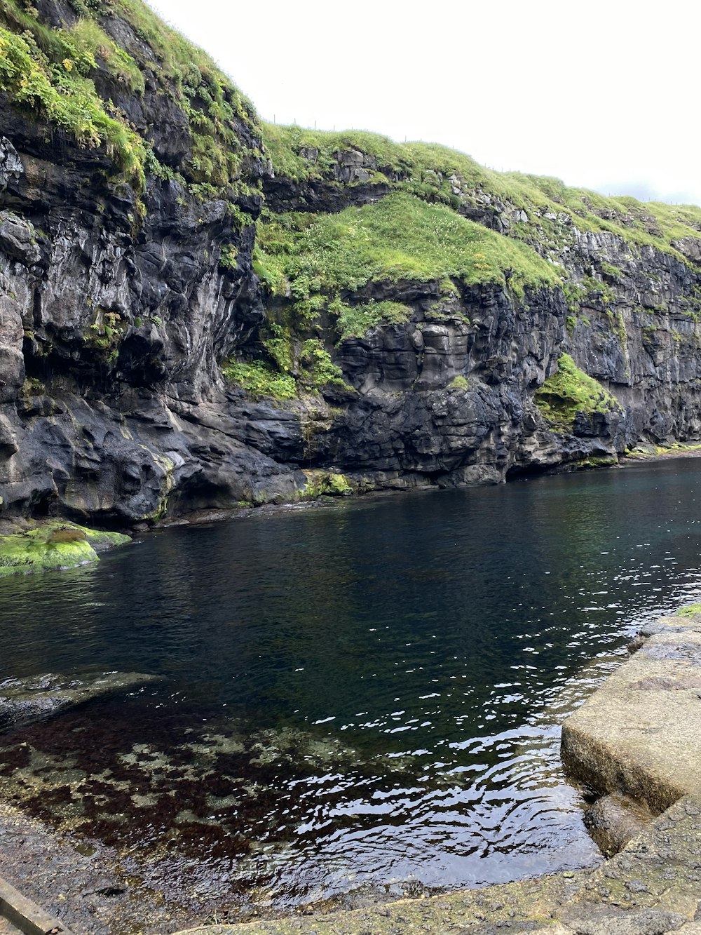 a body of water with cliffs on the side