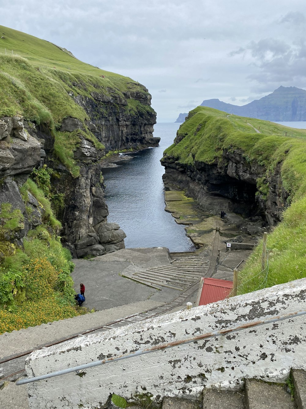 a person walking on a path next to a body of water