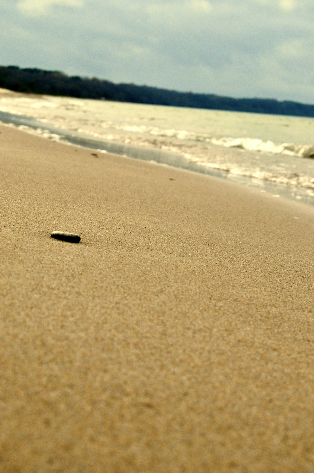 a sandy beach with waves crashing on it