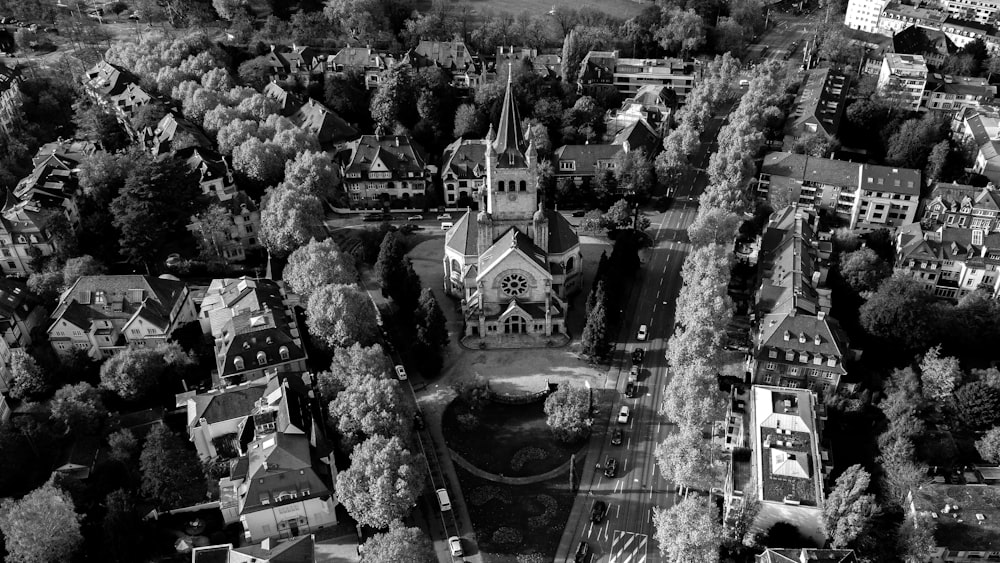 a black and white photo of a town with a church and a river