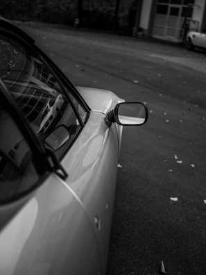 Wide angle view of a precheck auto inspector taking notes beside a classic car.