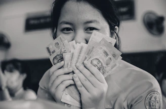 a person holding a stack of money