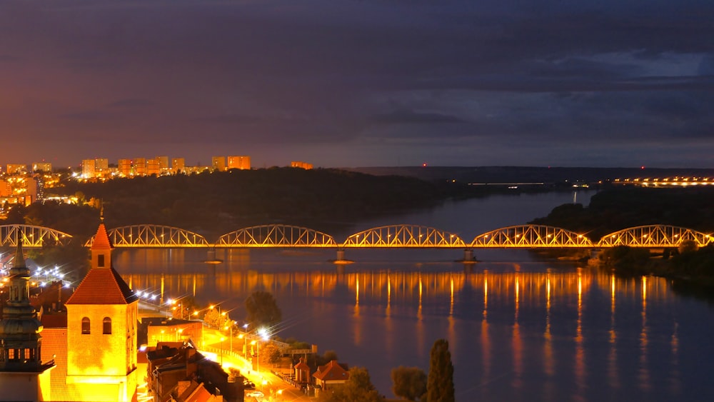 a bridge over a river with a city in the background