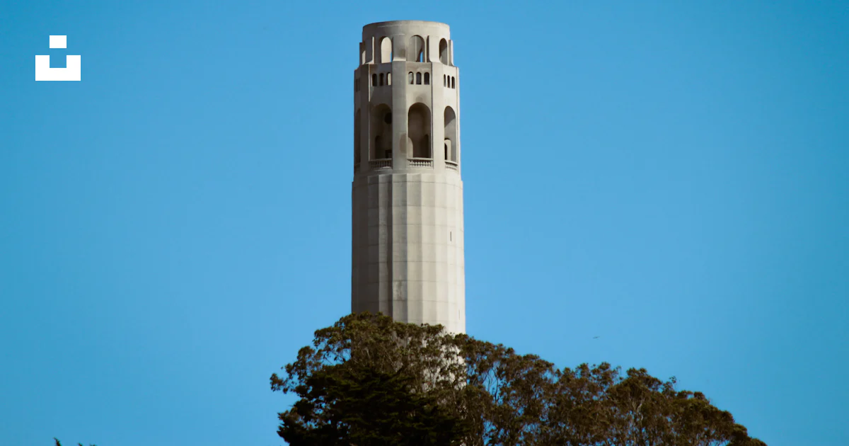 Torre Coit Una alta torre blanca con Coit Tower al fondo foto – Imagen de San ...