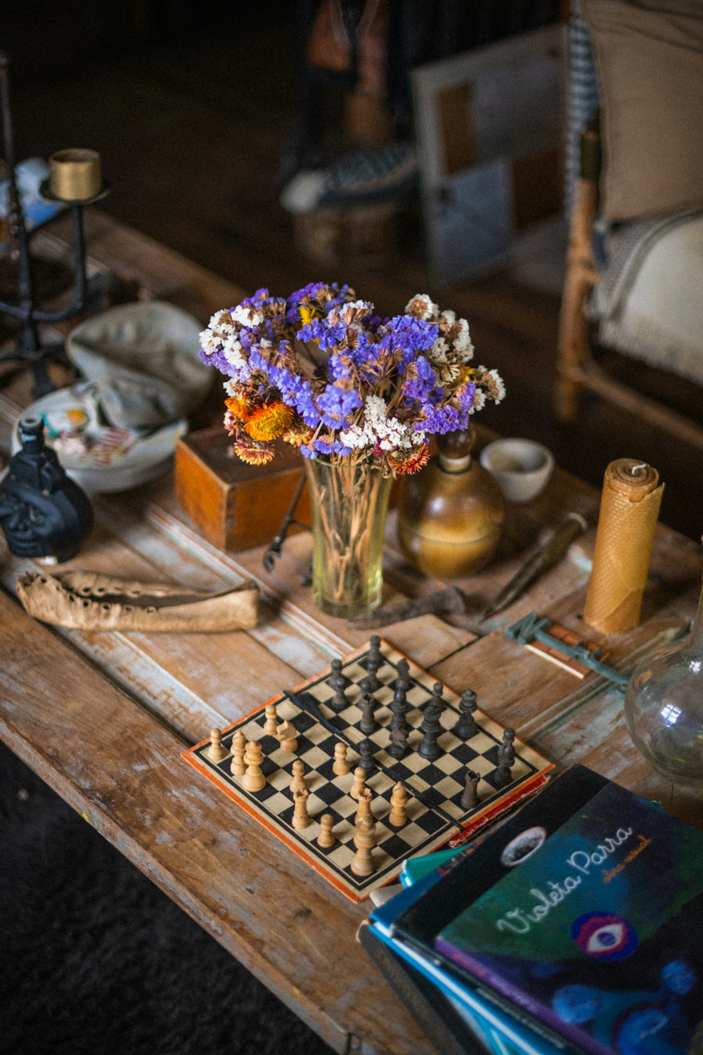 a table with a vase of flowers and a book
