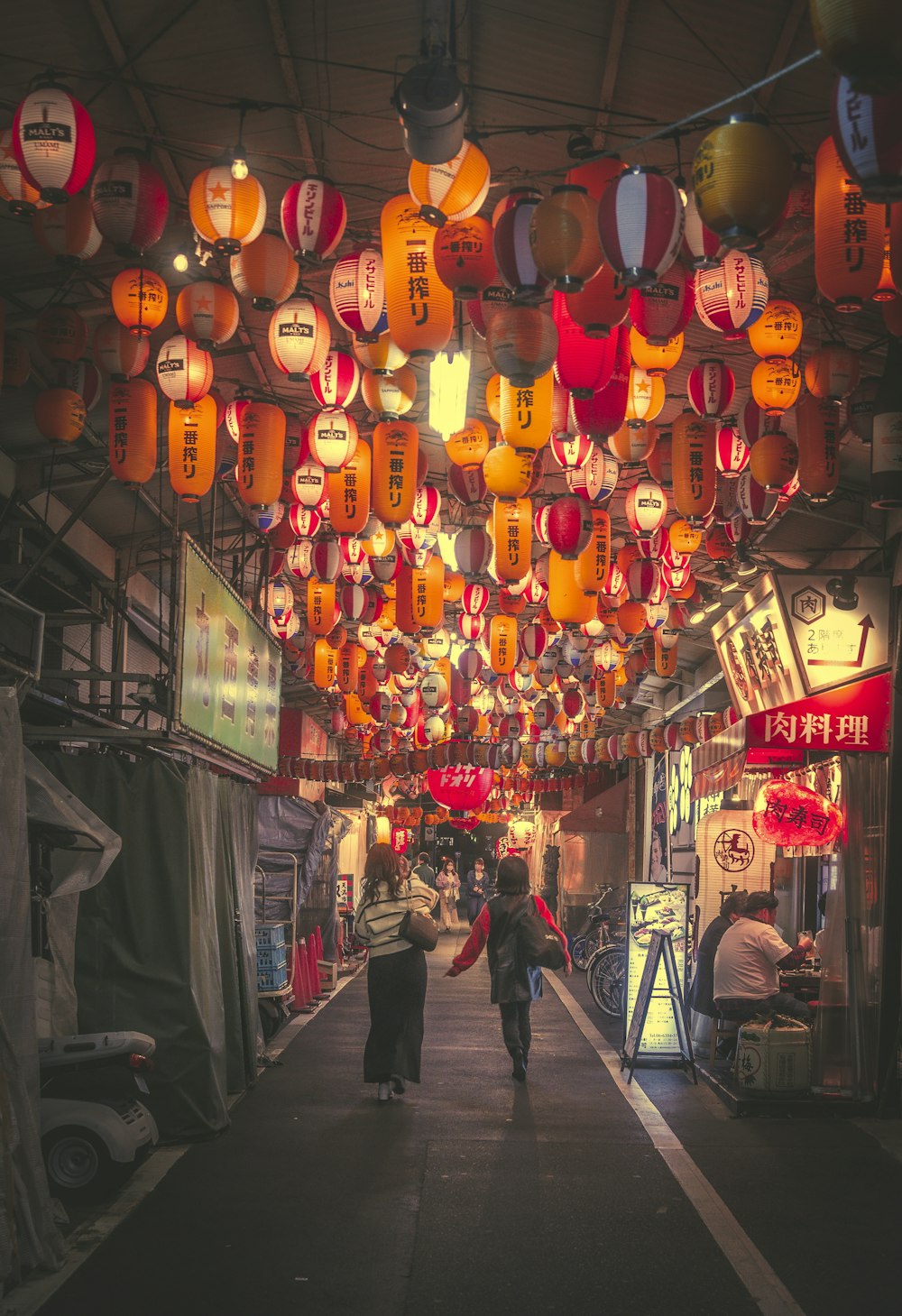 a street with lanterns from the ceiling